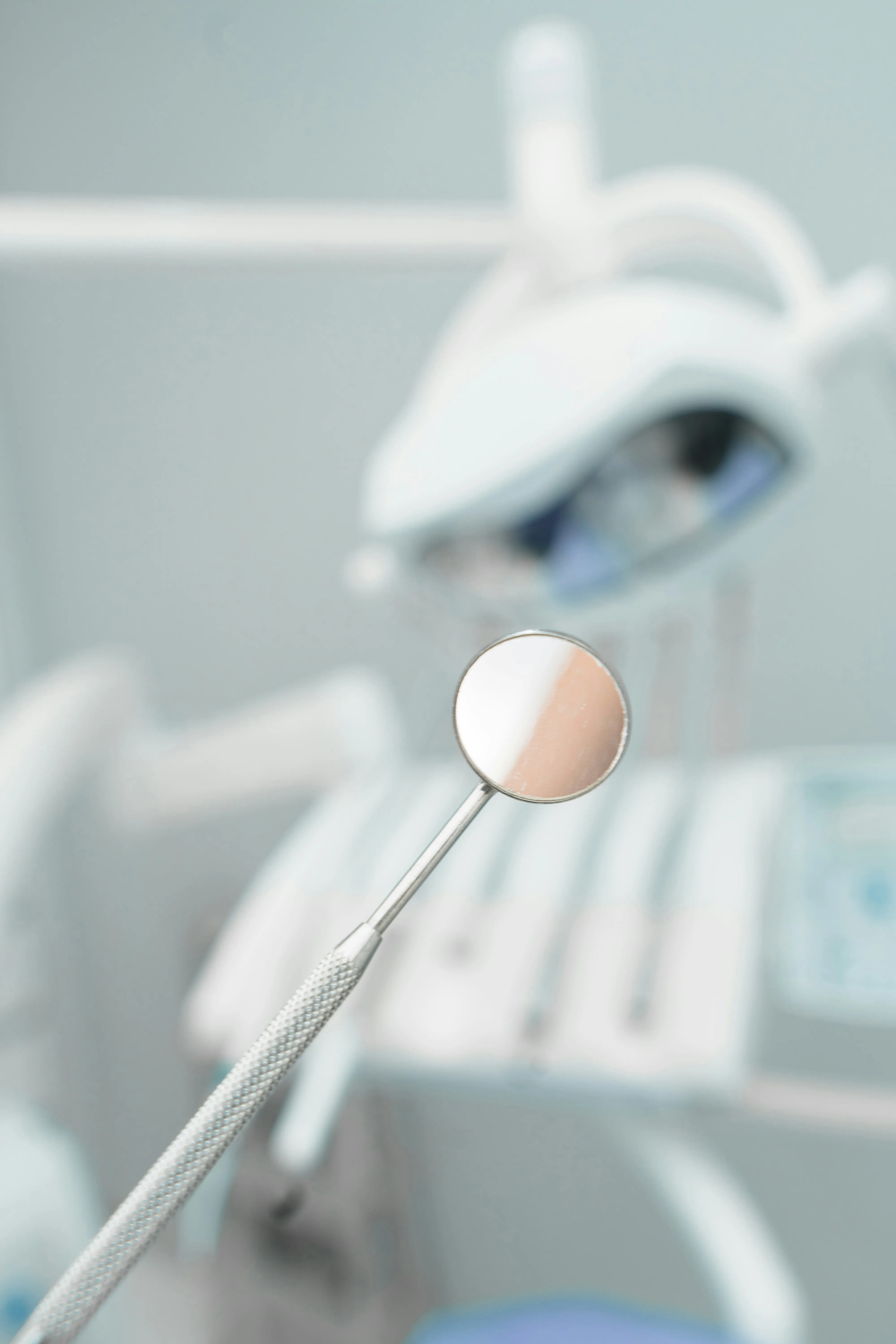 A dental mirror and examination instruments laid out on a tray